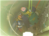 Mannequin, simulating a victim, is removed from a below-ground space at a confined space training.