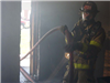Firefighter advances hose line at a live fire training drill.